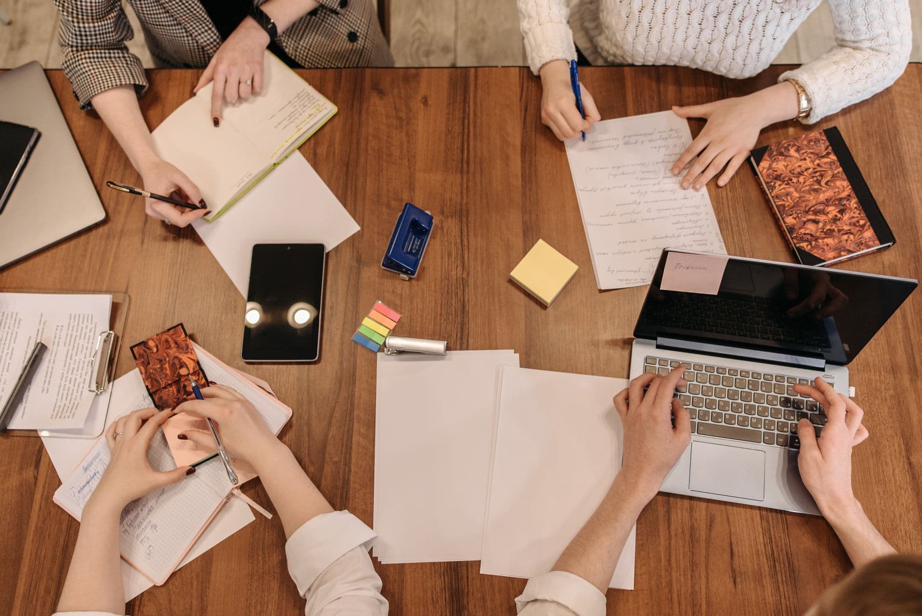Bovenaanzicht van mensen die samen aan een inhoudelijk project werken