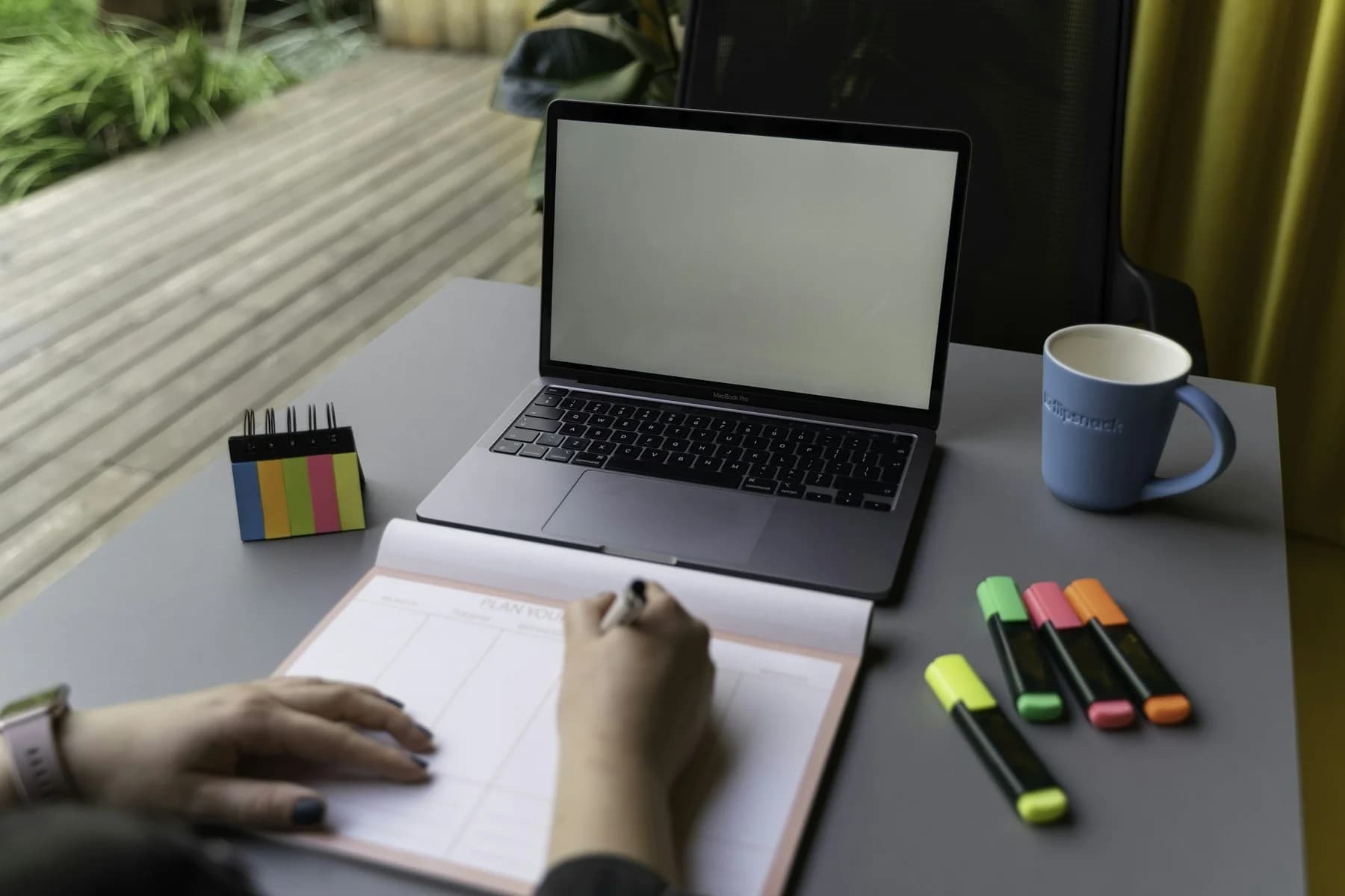 Projectplanning met laptop, notities en markeerstiften